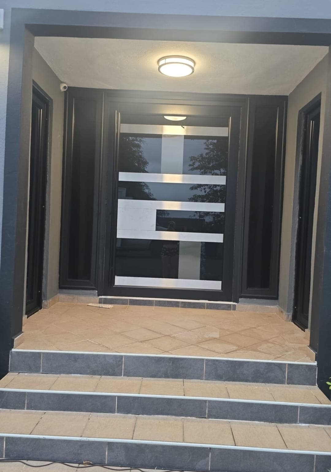 Entrada contemporánea negra con detalles horizontales en acero